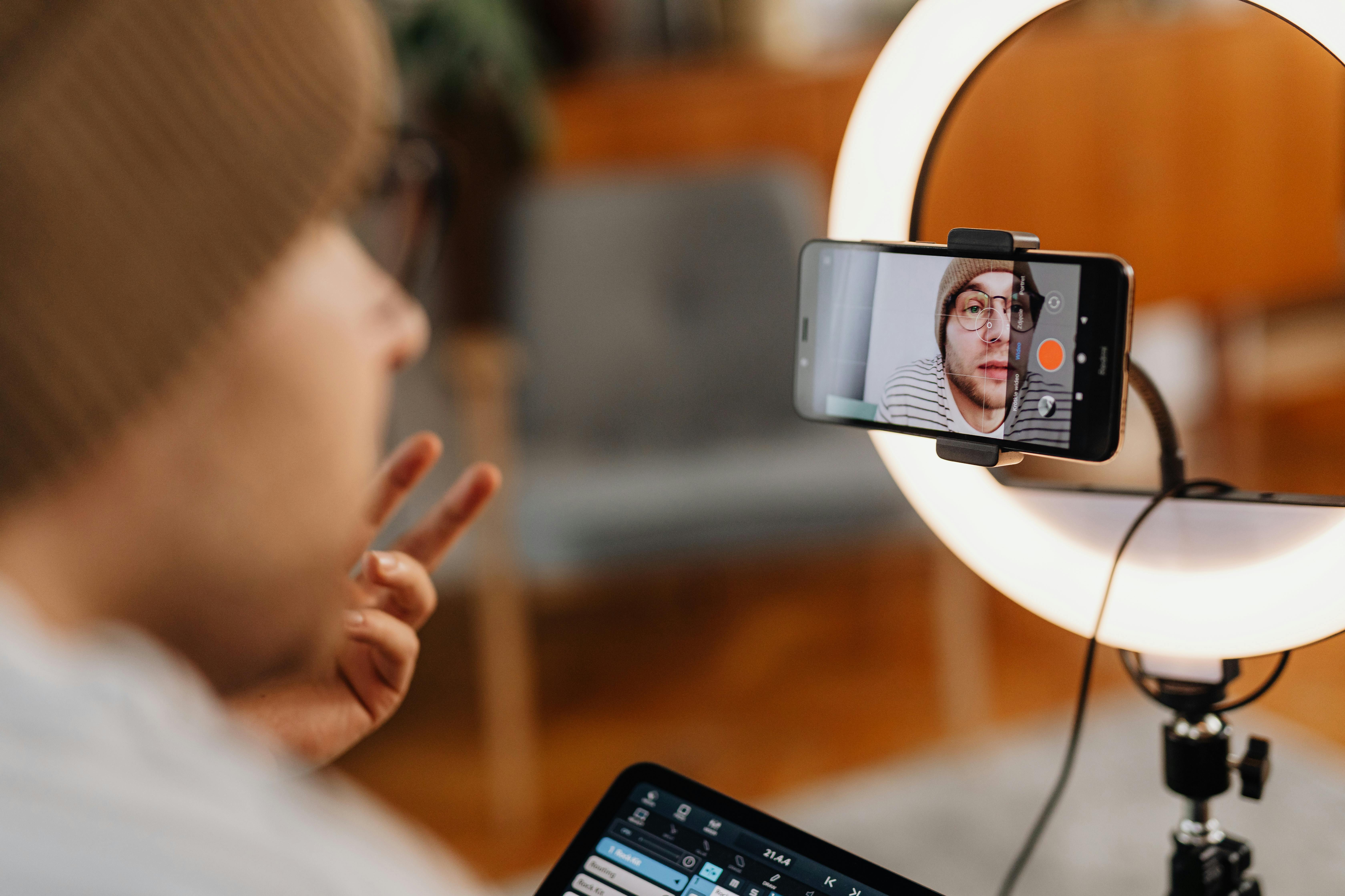 A content creator set up in front of a ring light and smartphone